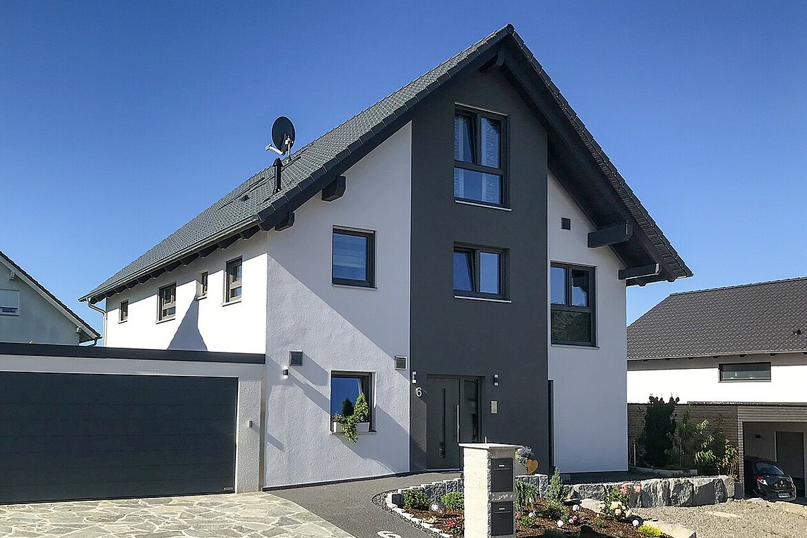Das Haus der Bauherrenfamilie mit grauem Dach und grauen Akzenten