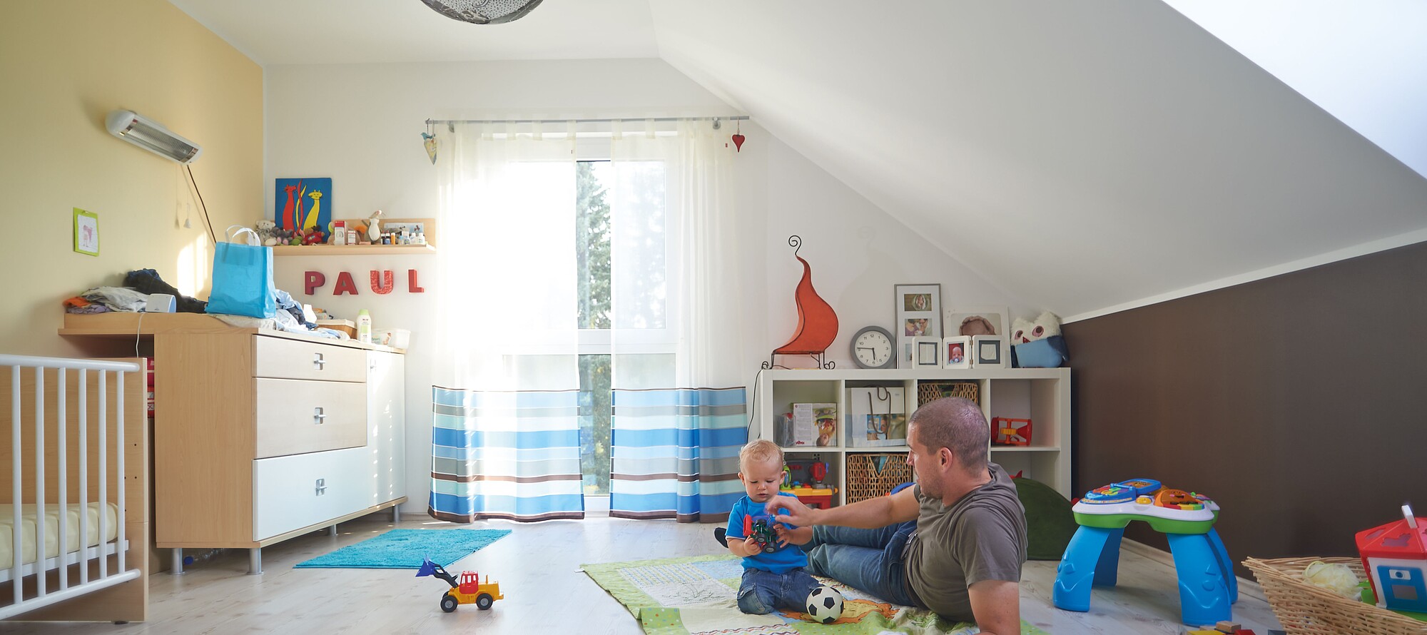 Hanse Haus Kundenhäuser Vater und KInd spielen in einem Kinderzimmer in einem Fertighaus erbaut von Hanse Haus