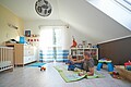 Vater und KInd spielen in einem Kinderzimmer in einem Fertighaus erbaut von Hanse Haus